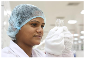 An employee at SCHOTT Kaisha’s production facility in Jambusar inspects two glass vials